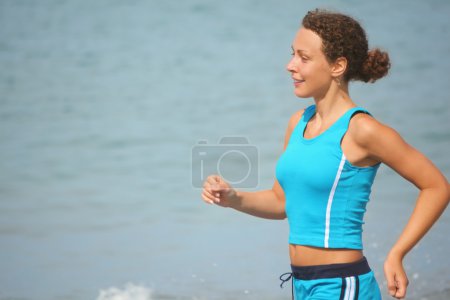 Woman is making exercise on sea coast