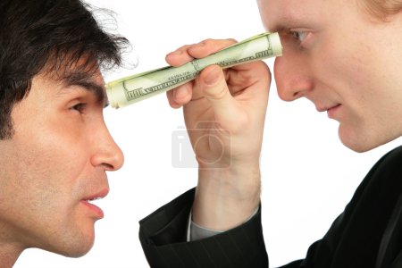 One businessman looks at another through small tube from dollar