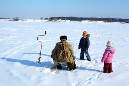 Two children and fisherman on frozen river