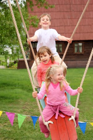 Three children on swing