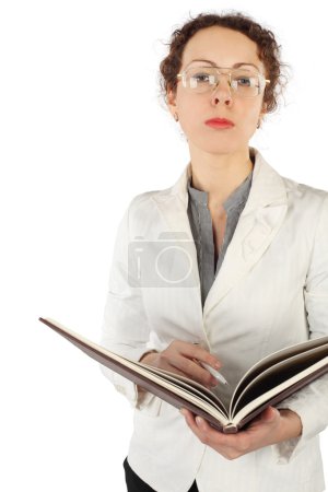 Young serious woman in glasses holding big book and pen, looking