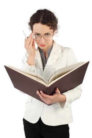 Young serious woman arranging glasses and holding big book and p