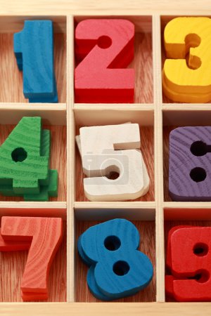Math game for junior age with colored wooden signs of numbers ve