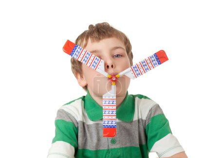 Boy in striped T-shirt with toy propeller in mouth isolated on