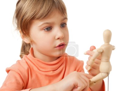 Pretty little girl is played by wooden little manikin isolated o