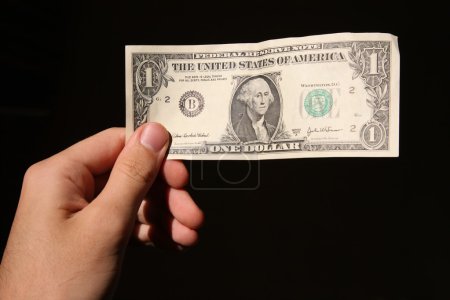 Hand and one dollar isolated on black backgrounds 2