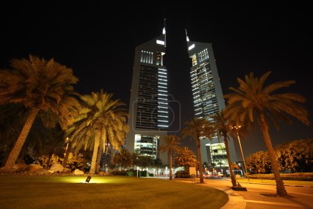 DUBAI - APRIL 18: Emirates Towers and area with palms and grass