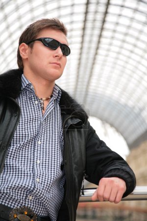 Young man in black jacket and sunglasses