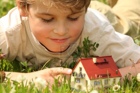 Boy and house model in grass