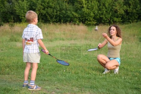 Mother plays with son in badminton
