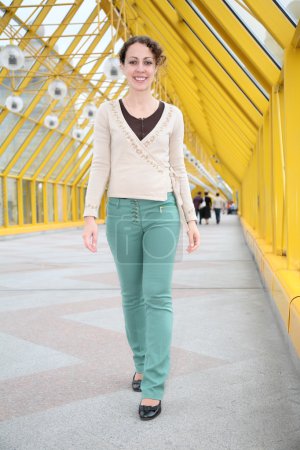 Young woman goes on pedestrian bridge