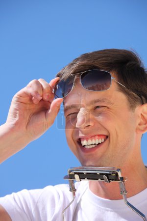 Laughing guy with lip accordion and sun glasses