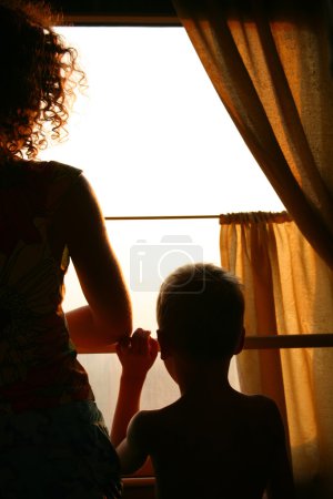 Mother and child look in train window