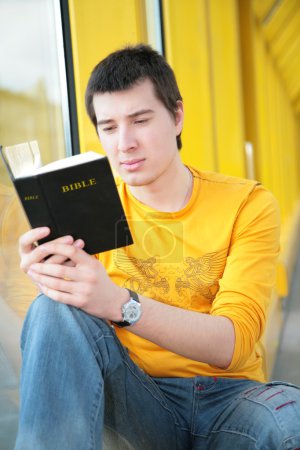 Asian boy reads bible