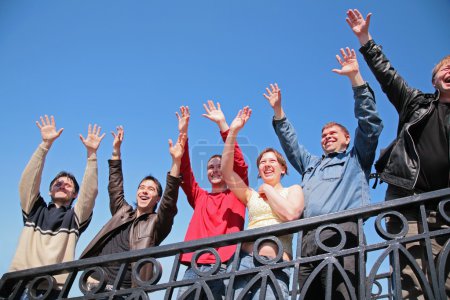 Group of stand with hands lifted in greeting