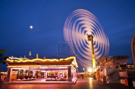 Spinning vertical ride at carnival with moving light blur
