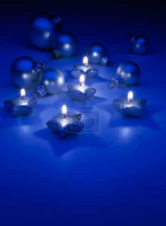 Art Christmas candles and ornaments on a blue background
