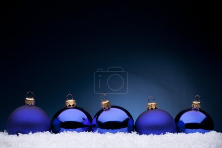 Blue Christmas balls in the white snow