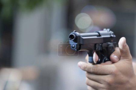 Man holding gun aiming pistol in hand ready to shoot