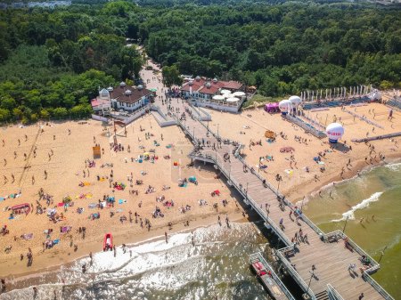 Gdansk, Poland - August 3, 2019: People relaxing on the beach with wooden pier at Baltic Sea in Gdansk, Poland.