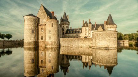 Castle or chateau de Sully-sur-Loire in sunset light, France. This old castle is a famous landmark of Loire Valley. Panorama of the medieval castle on the river. French vintage castle in evening.