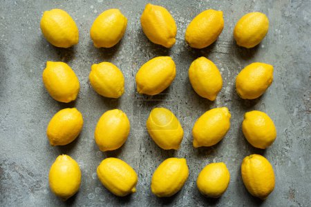 flat lay with ripe yellow lemons on concrete textured surface