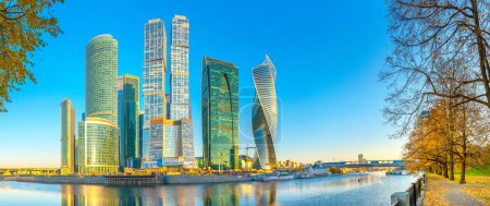 Panorama of the skyscrapers of the business center of Moscow from the embankment of the Moskva River at sunrise, reflection of buildings in the river, Moscow, Russia