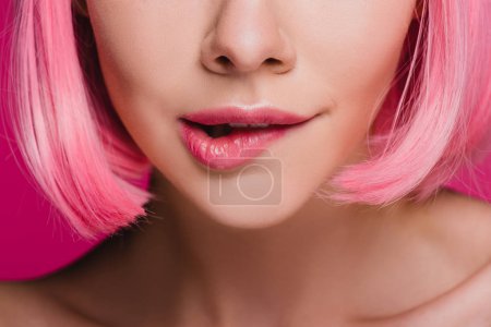 cropped view of sensual girl biting lip on pink