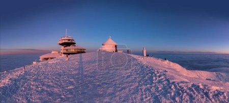 The peak of the Snezka Mountain in winter in the Krkonose Mountains. Panorama Snezka after a sunset tinged in beautiful pastel colors from Poland side.