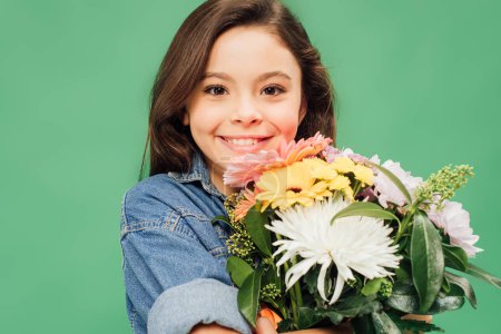 adorable smiling child with flower bouquet looking at camera isolated on green