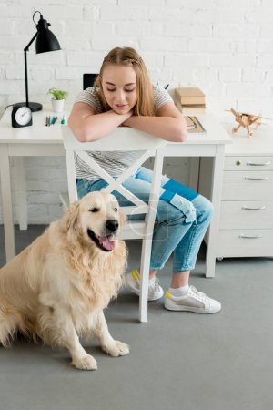 smiling teen girl spending time at home with her dog