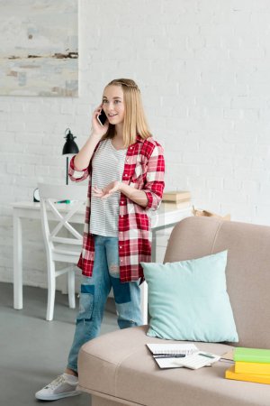 beautiful teen girl in red plaid shirt talking by phone at home