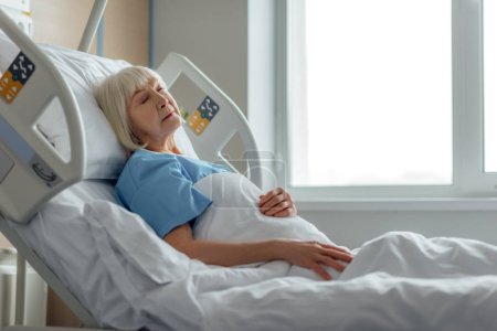 selective focus of senior woman sleeping in hospital bed