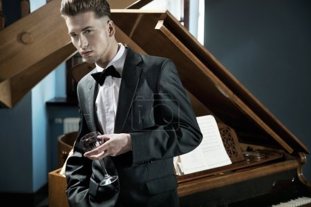 Young pianist with glass of wine