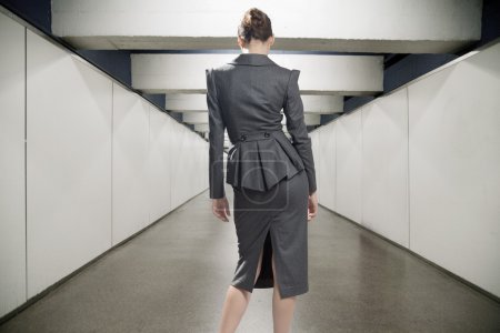 Conceptual image of a young businesswoman in a corridor