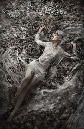 Fine art photo of a sexy woman lying on leaves
