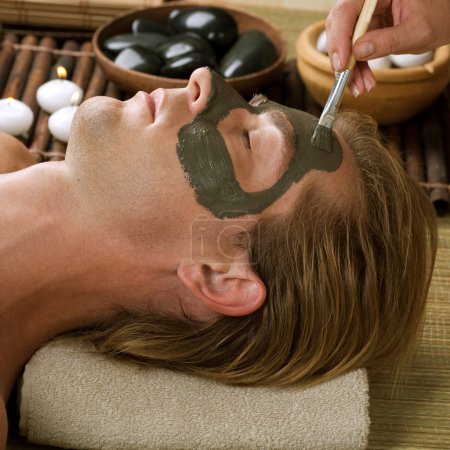 Spa. Handsome Man With A Mud Mask On His Face
