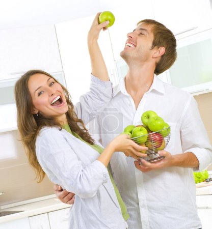 Happy Couple Eating fresh fruits.Having fun on a kitchen.Dieting