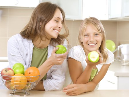Happy Family Mother with her Daughter eating Healthy food. Diet.
