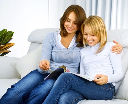 Mother with Teenage Daughter reading fashion Magazine