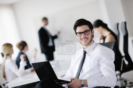 Portrait of a handsome young business man with colleagues in background