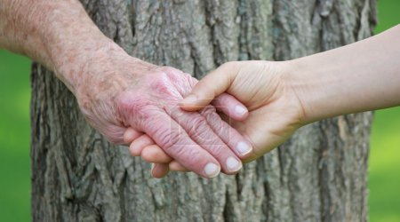 Senior and young woman holding hands