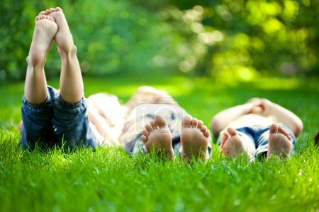 happy children lying on green grass