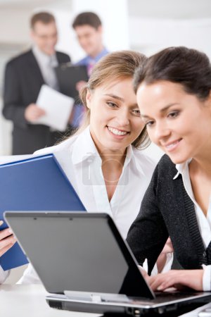 Portrait of two smiling business women working together