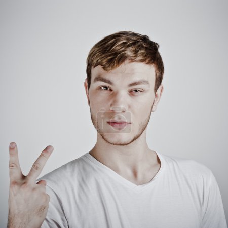 Young man holding up two fingers