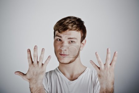 Young man holding up ten fingers