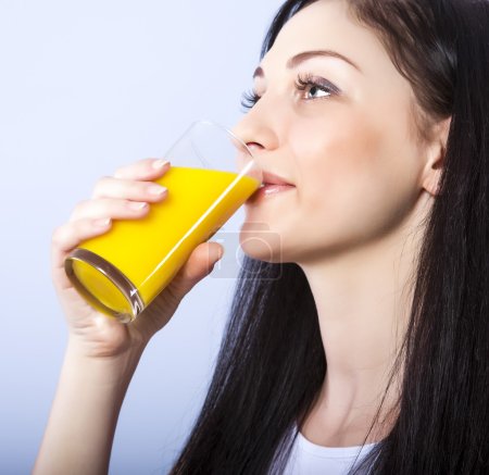 Beautiful girl drinks natural orange juice