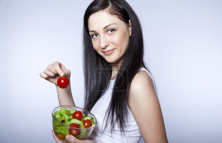 Portrait of pretty young girl eating vegetable salad