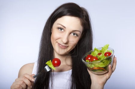 Portrait of pretty young girl eating vegetable salad