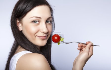 Portrait of a beautiful woman with a tomato